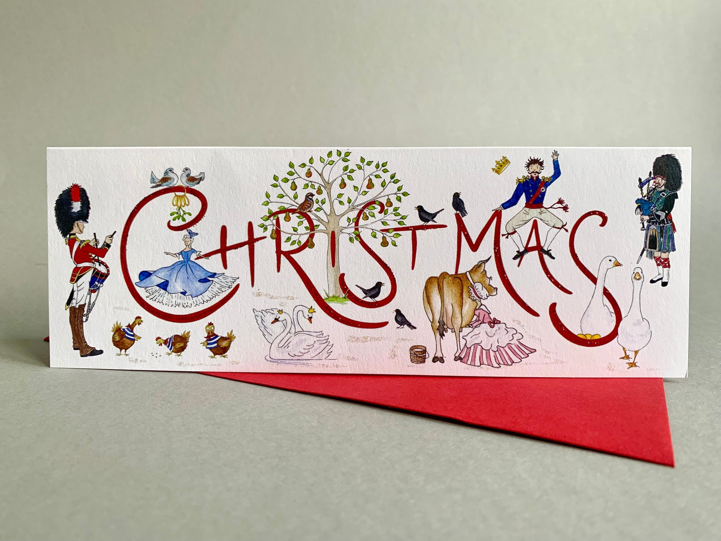 Showing original watercolour design of characters from this traditoinal carol, and resting on a coordinating crimson envelope.