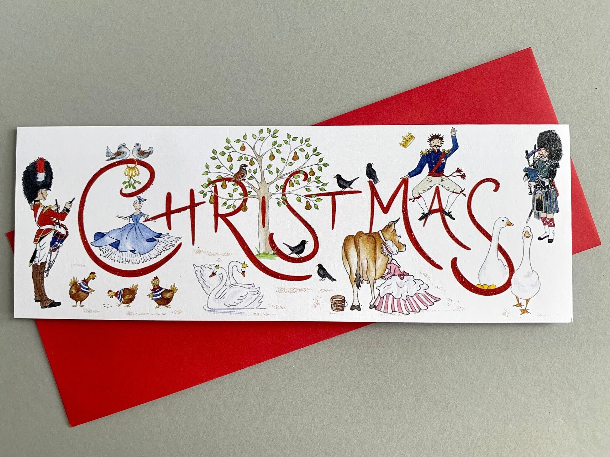 A traditional Christmas card with my own handwritten 'Christmas' text and a series of hand-painted watercolour illustrations of characters from the twelve days of Christmas rhyme. Shown with matching red envelope.