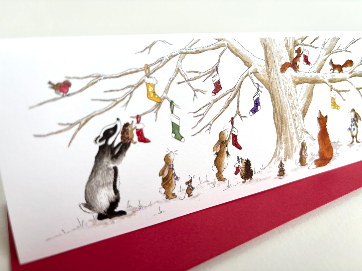 Glitter on snowy branches and christmas stockings for christmassy feel with crimson envelopes for a touch of elegance.
