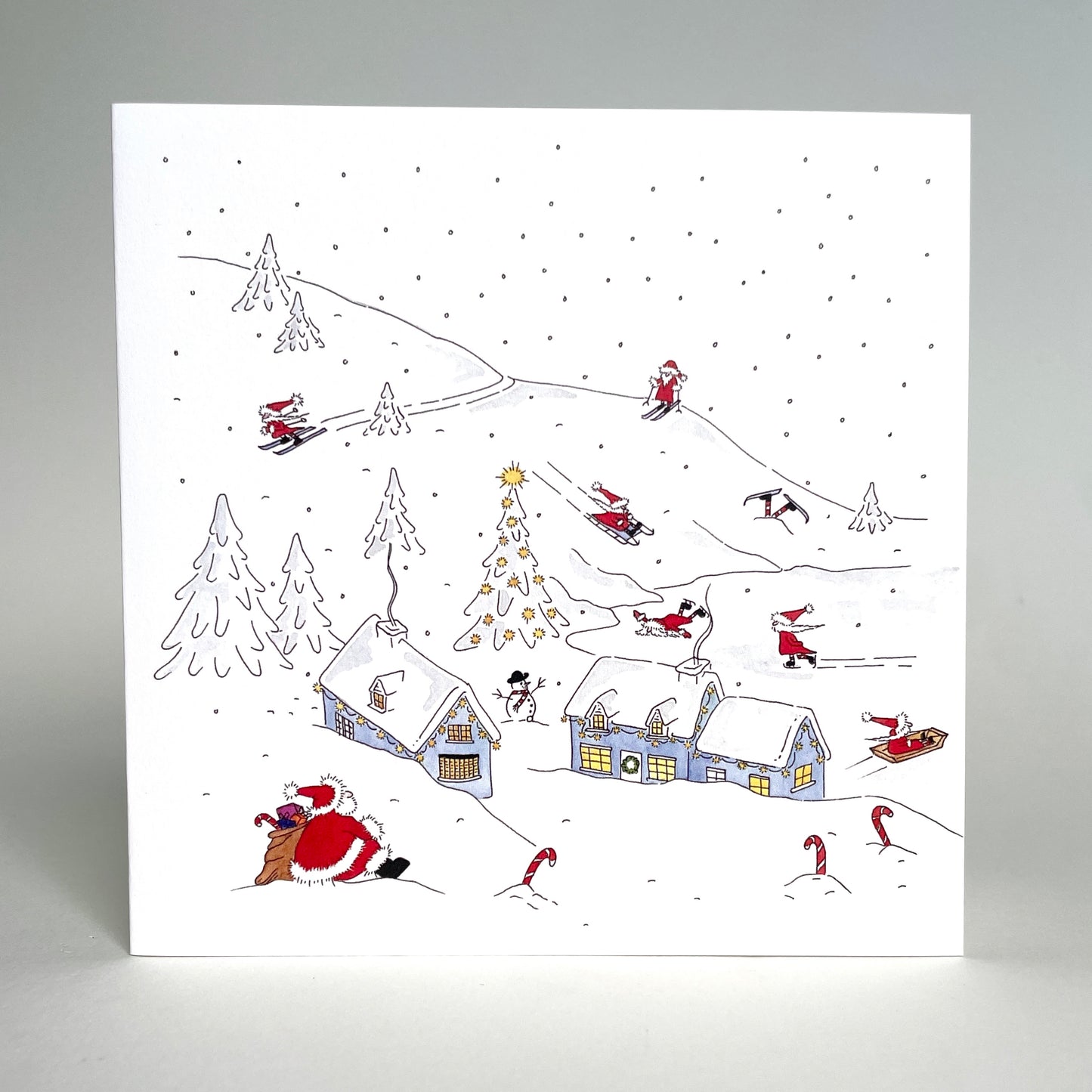 Standing image of charity Christmas card winter snow scene - an original design featuring Father Christmas and his elves in their North Pole village home