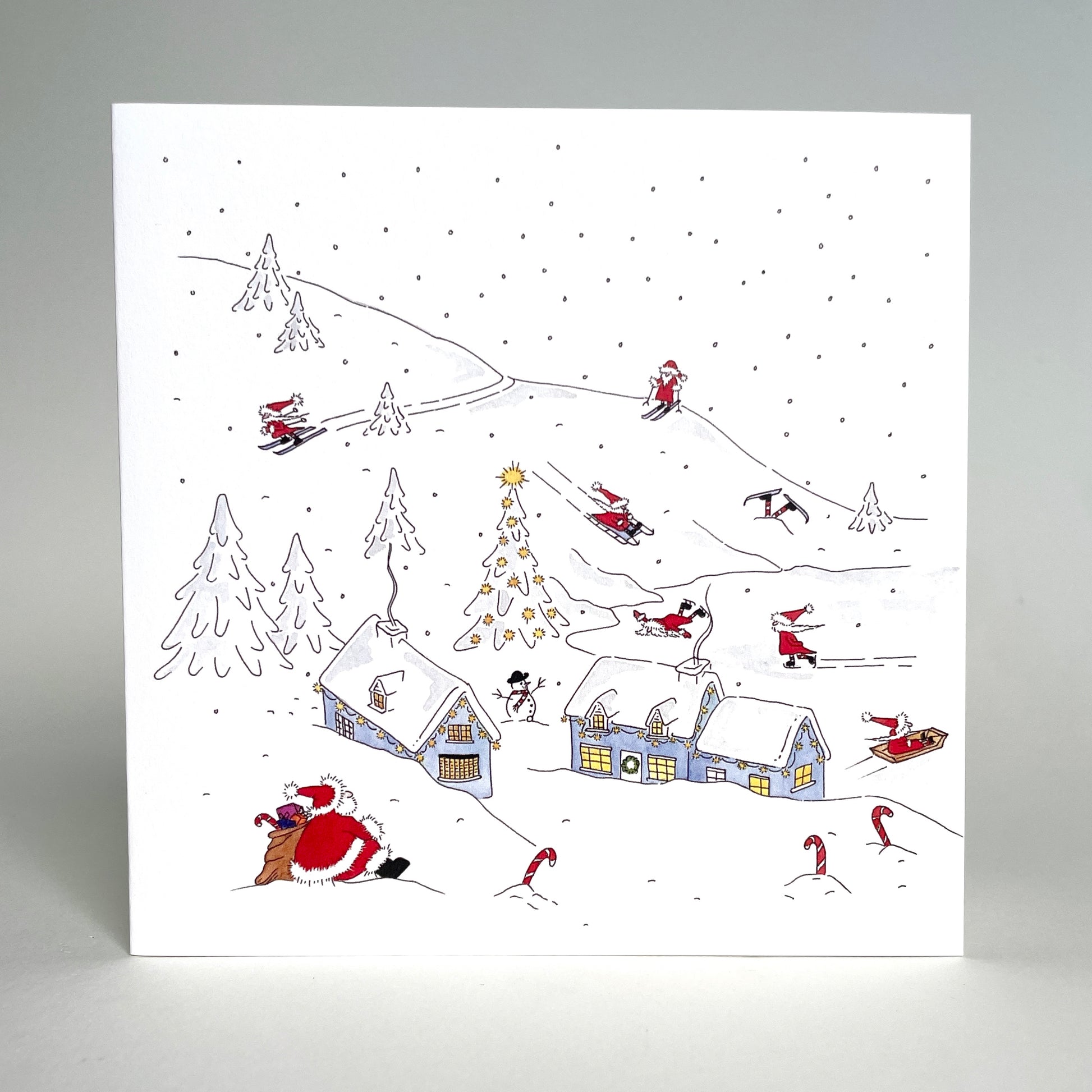 Standing image of charity Christmas card winter snow scene - an original design featuring Father Christmas and his elves in their North Pole village home