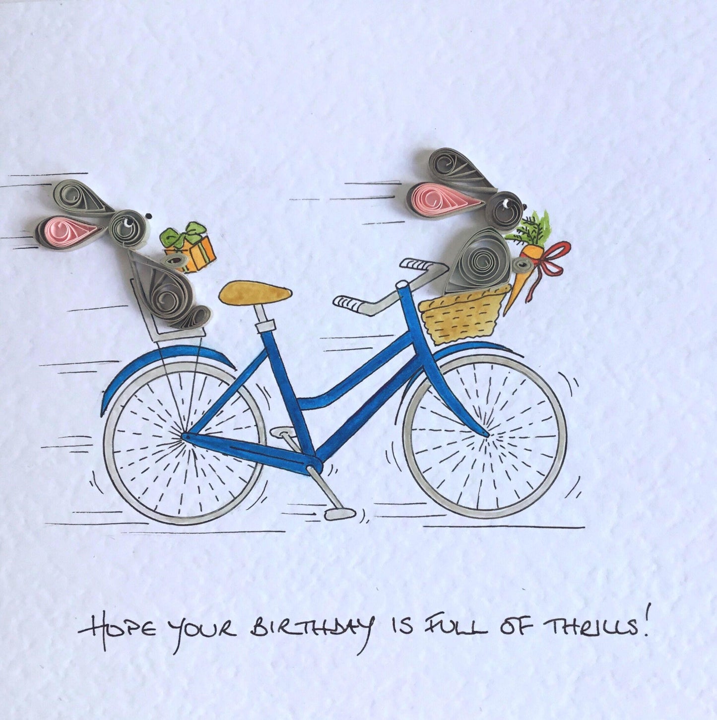Close-up of detail for handmade cycling card featuring two quilled rabbits racing on hand painted bicycle.