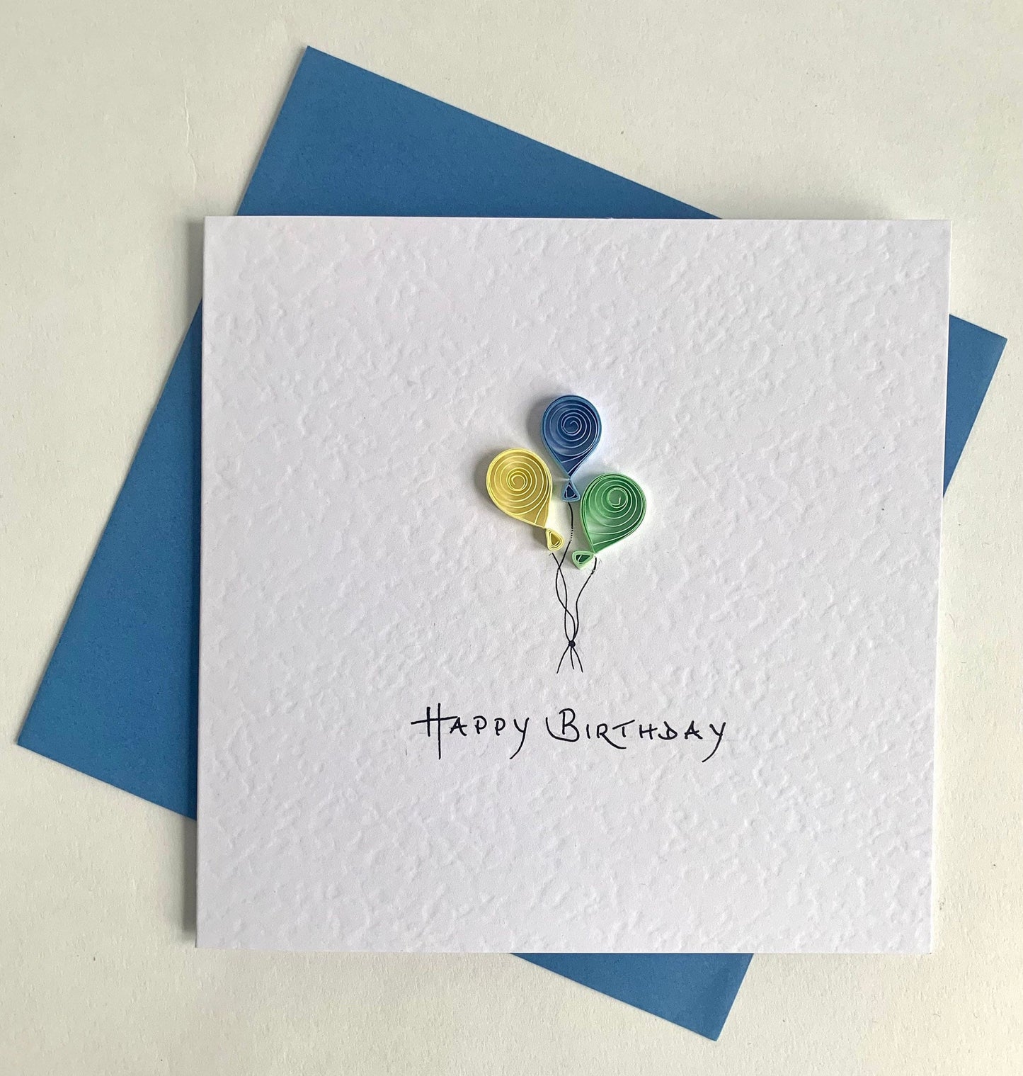 3 quilled balloons - blue, yellow and green version. supplied with blue envelope. Happy Birthday handwritten caption 