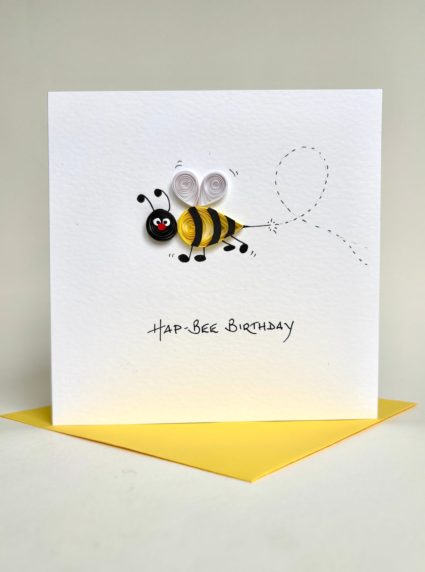 Handmade birthday card with a quilled bee design and 'Hap-Bee Birthday' text on a white background.