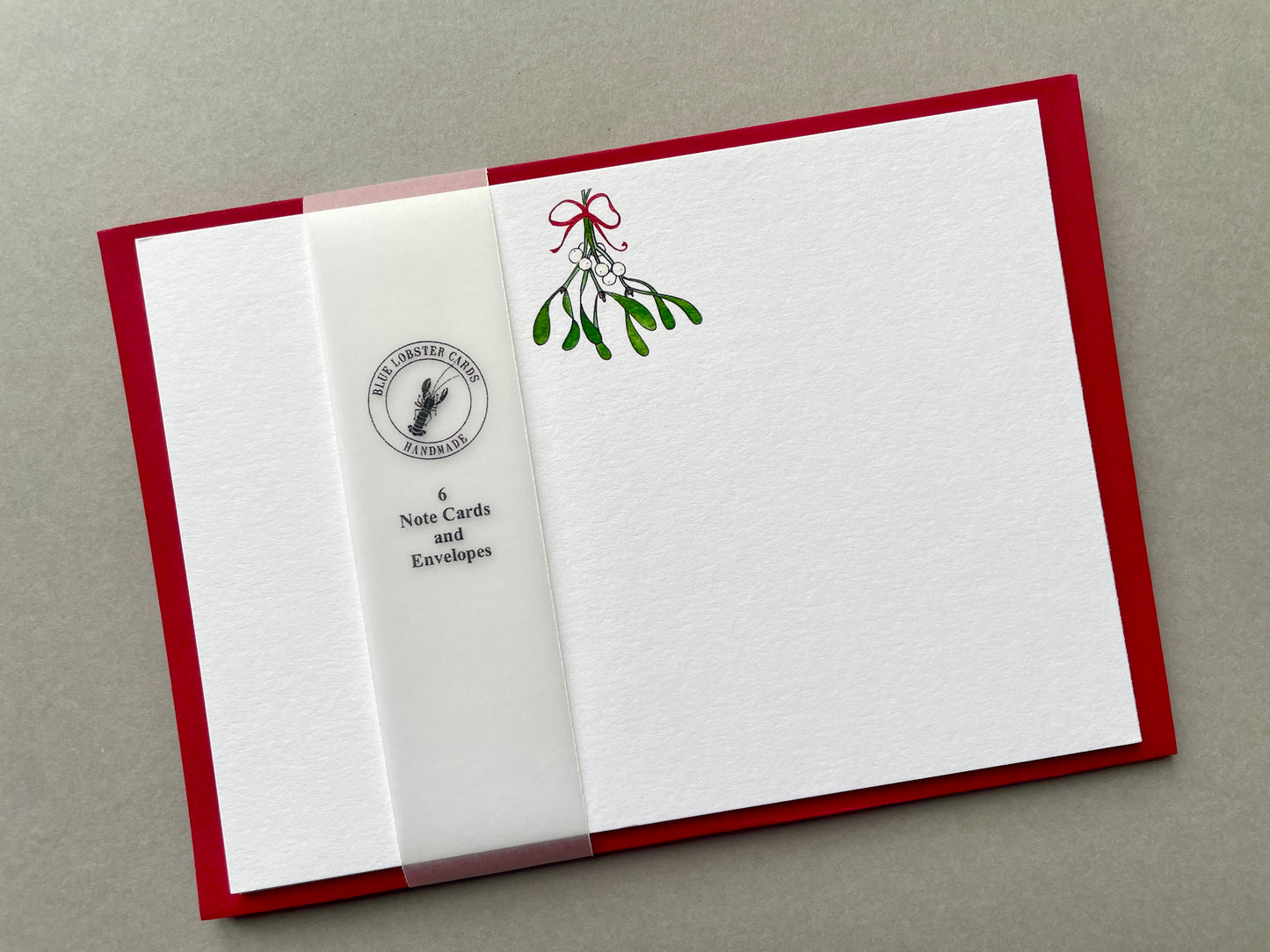 Pack of 6 Mistletoe Christmas notecards with coloured envelopes, presented in a recyclable Blue Lobster Cards belly band.