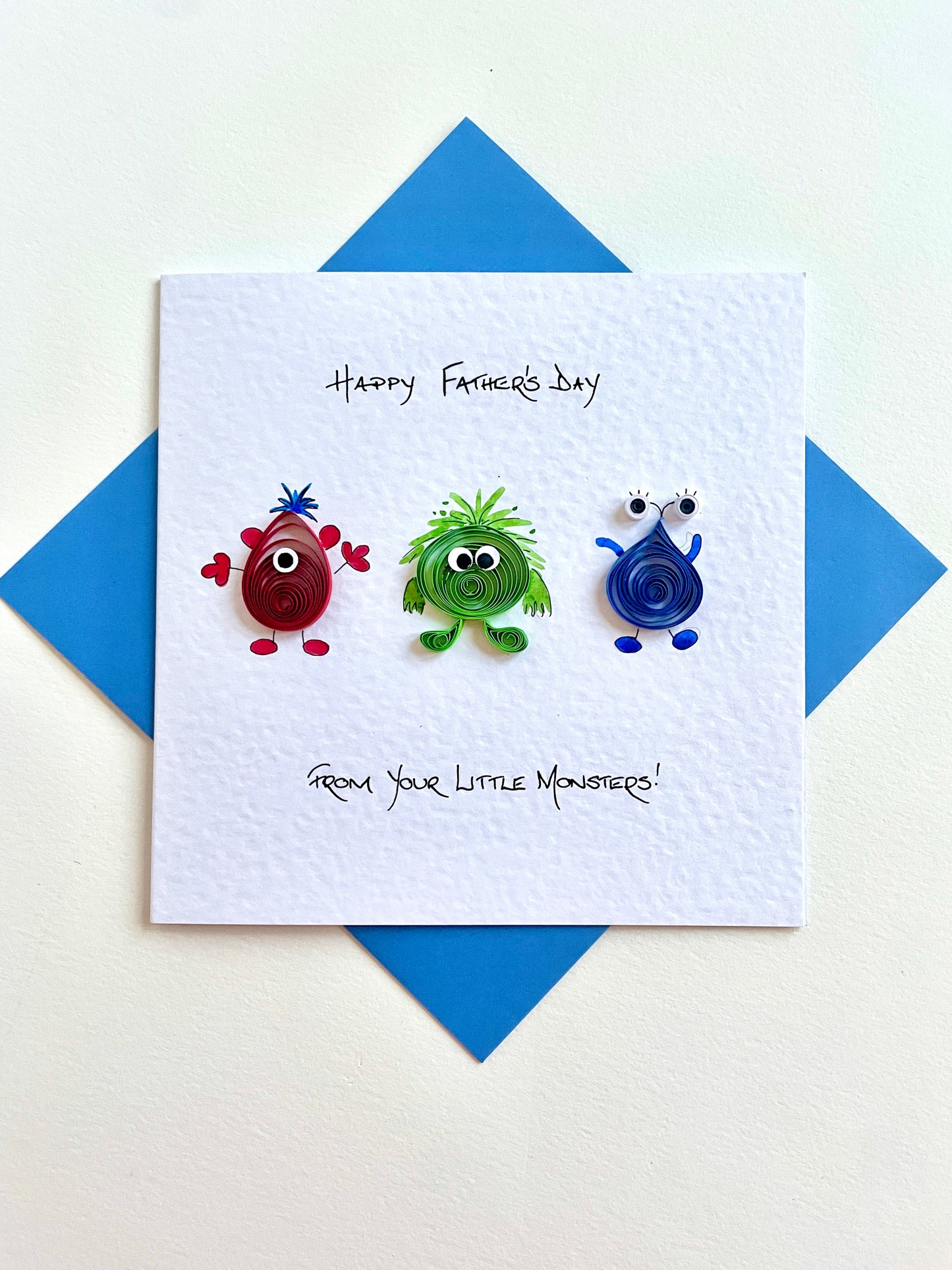 Funny Father's Day card with colourful monster designs on a blue envelope.