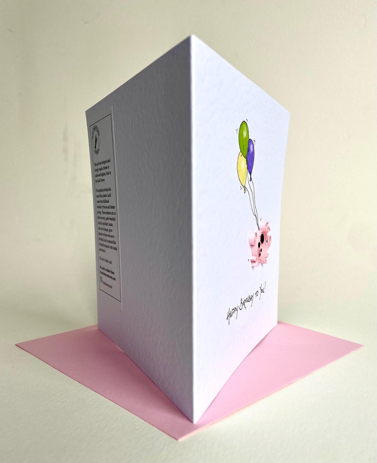 Profile of quilled pig birthday card showing raised quilling and reverse of card on envelope