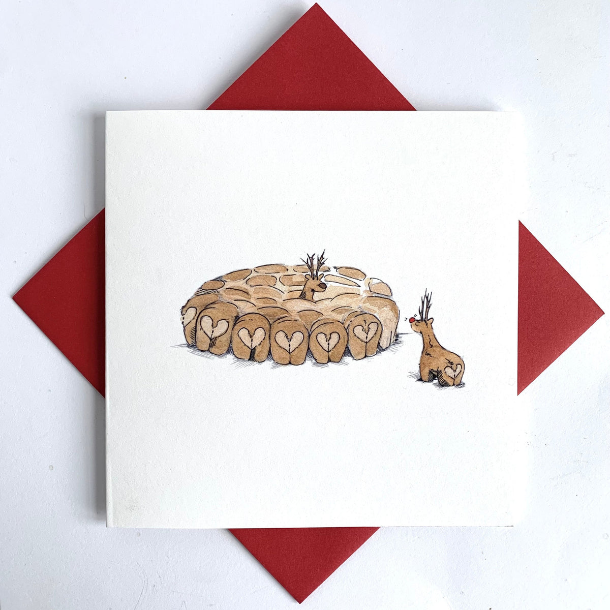Unique christmas card featuring reindeer love matchin a snowy background. Set against striking red christmas envelope