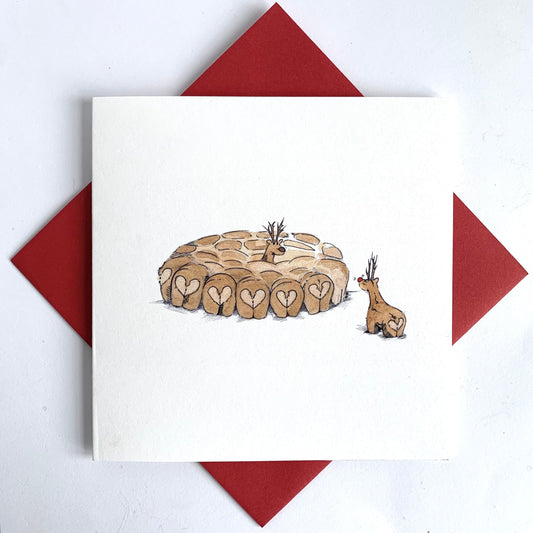 Unique christmas card featuring reindeer love matchin a snowy background. Set against striking red christmas envelope