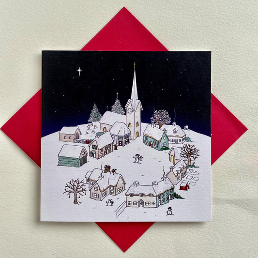 Original watercolour charity Christmas card showing a snowy village and church beneath a deep starry Christmas night sky.
