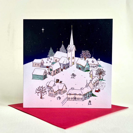 135mm square Snowy Village Christmas card shown with its crimson red envelope.