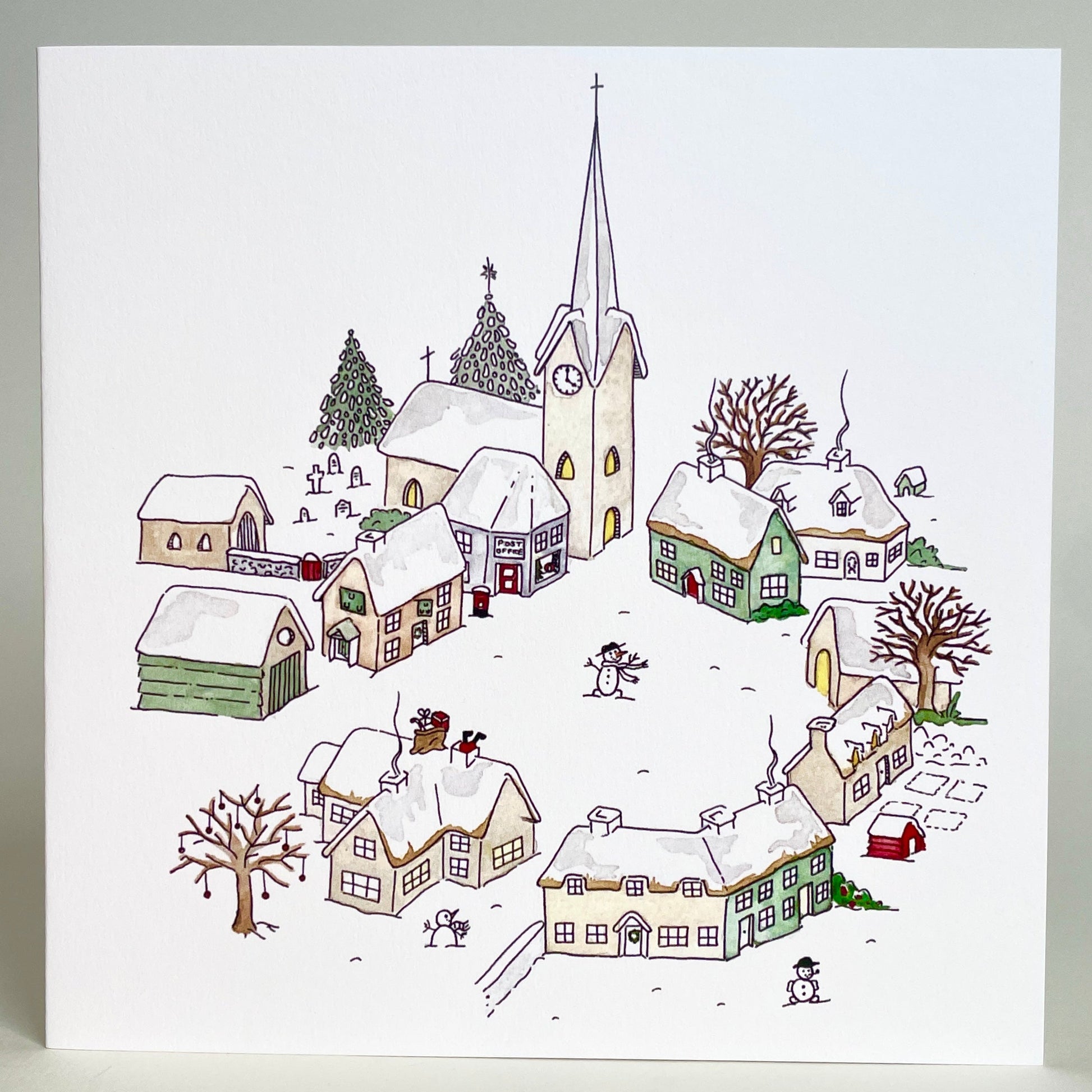 Classic christmas watercolour design of snow-covered houses and features. Printed in UK