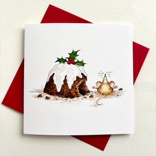 A square charity Christmas card featuring a hand-painted illustration of a Christmas pudding topped with holly and a small mouse beside it. Shown with red envelope.