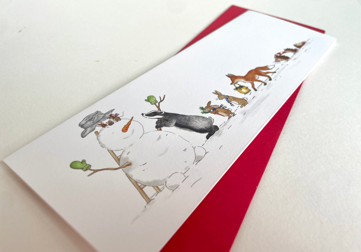 Close-up angled view of snowman and badger illustration, reproduced from original watercolour on 300gsm matt uncoated cardstock.