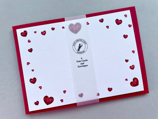 Card with heart designs and a visible brand logo on a gray background 